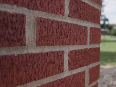 Handheld close up and slow motion view of vintage red brick pattern on outdoor surface, with warm and white textures